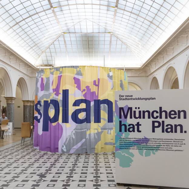 Blick in die Rathausgalerie auf ein großes PLakat auf dem steht "München hat Plan".