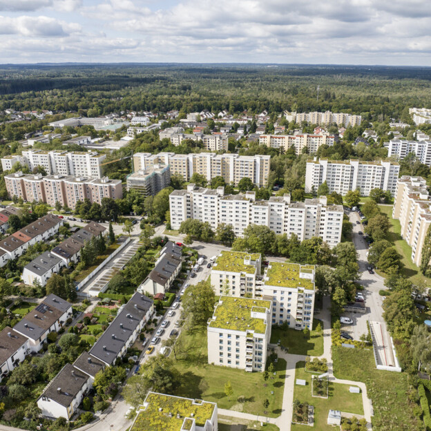 Luftbild der Wohnsiedlung Taufkirchen. Eine Mischung aus Hochhäusern und EInfamilienhäusern mit vielen Grünflächen ist zu sehen.